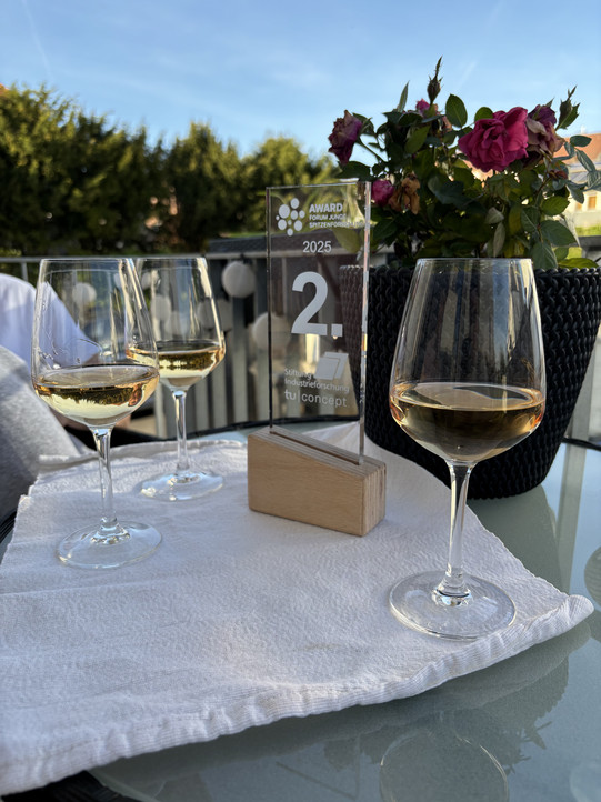 Award trophy on a table, filled wine glasses with white wine.