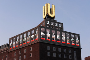 Das Dortmunder U mit Bildschirmen und blauem Himmel im Hintergrund.
